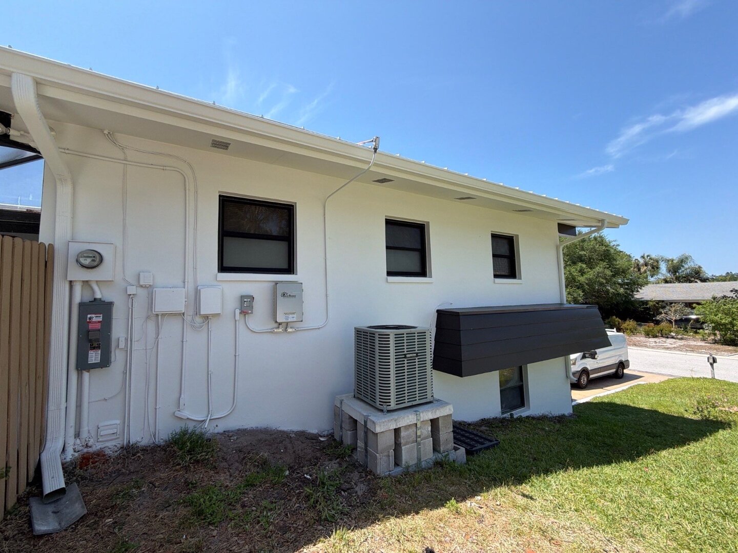 Dunedin home side wall after painting in white with dark accent AC cover